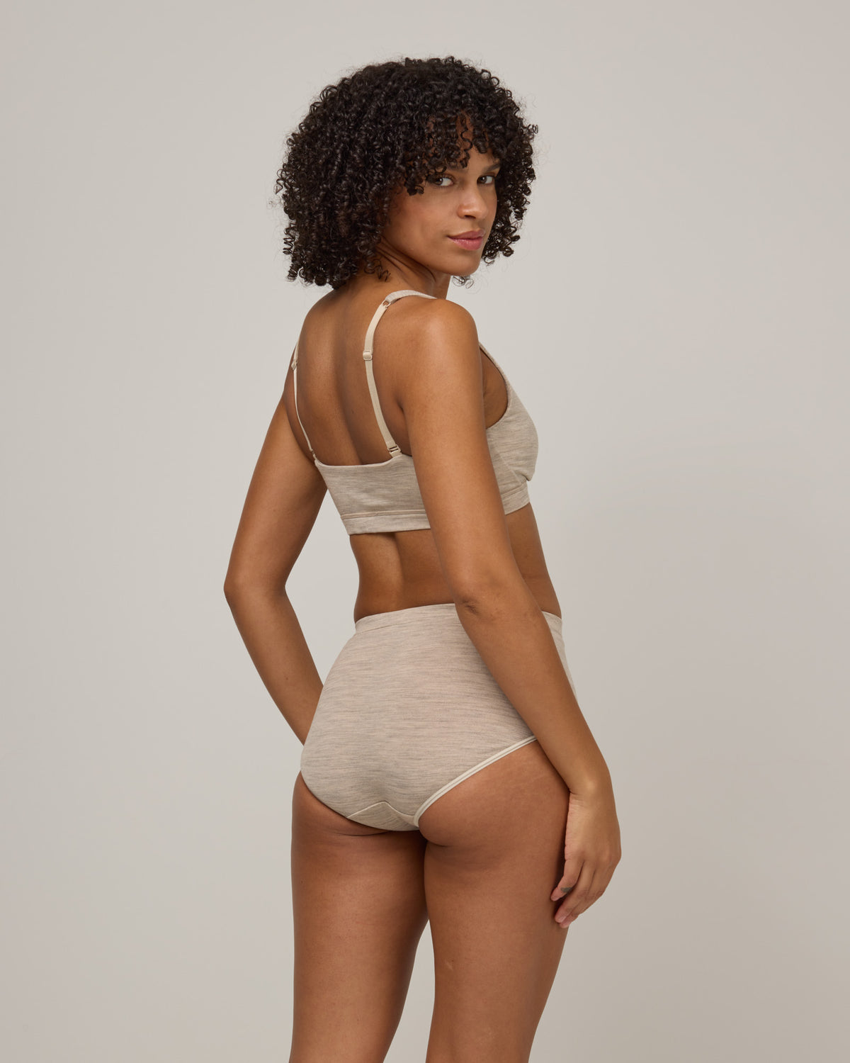 Model wearing Roam High Waist Bikini in Oatmeal Heather, a soft heathered cream color. Roam High Waist Bikini is a merino wool underwear available in sizes XS-3X.