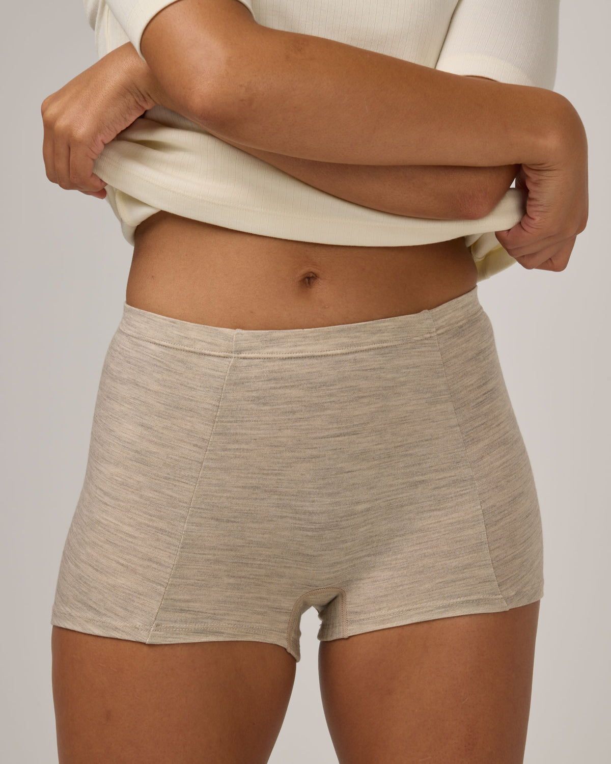 Model wearing Roam High Waist Shortie in Oatmeal Heather, a soft heathered cream color. Roam High Waist Shortie is a merino wool underwear available in sizes XS-3X.