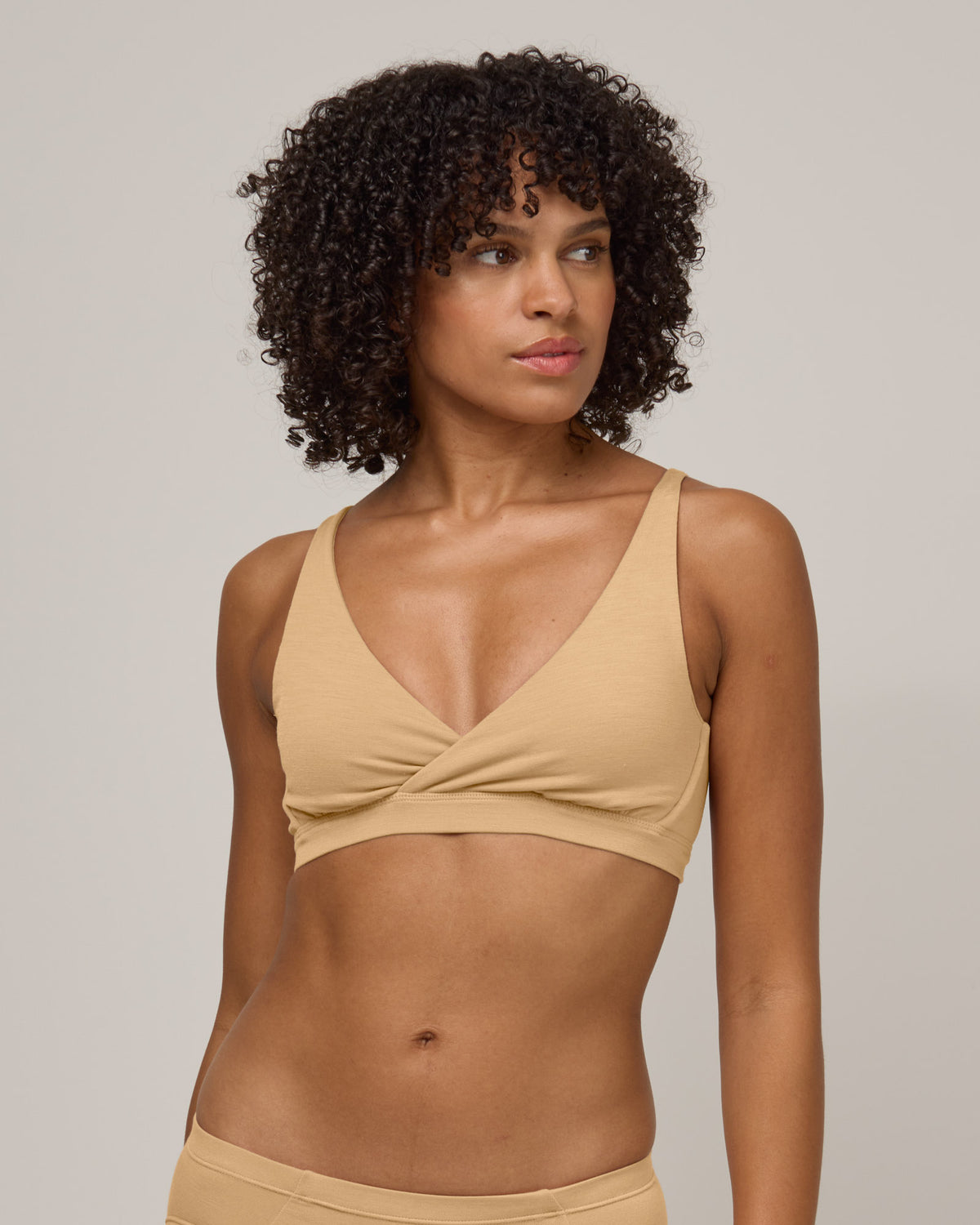 Model wearing Roam Convertible Wrap Bra in Fawn, a light nude color. Roam Convertible Wrap Bra is a merino wool underwear available in sizes XS-XXL.