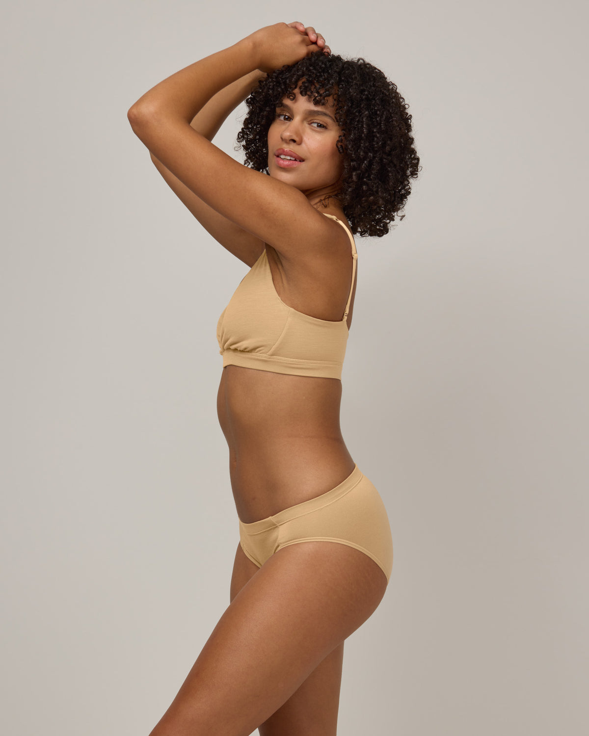 Model wearing Roam Convertible Wrap Bra in Fawn, a light nude color. Roam Convertible Wrap Bra is a merino wool underwear available in sizes XS-XXL.