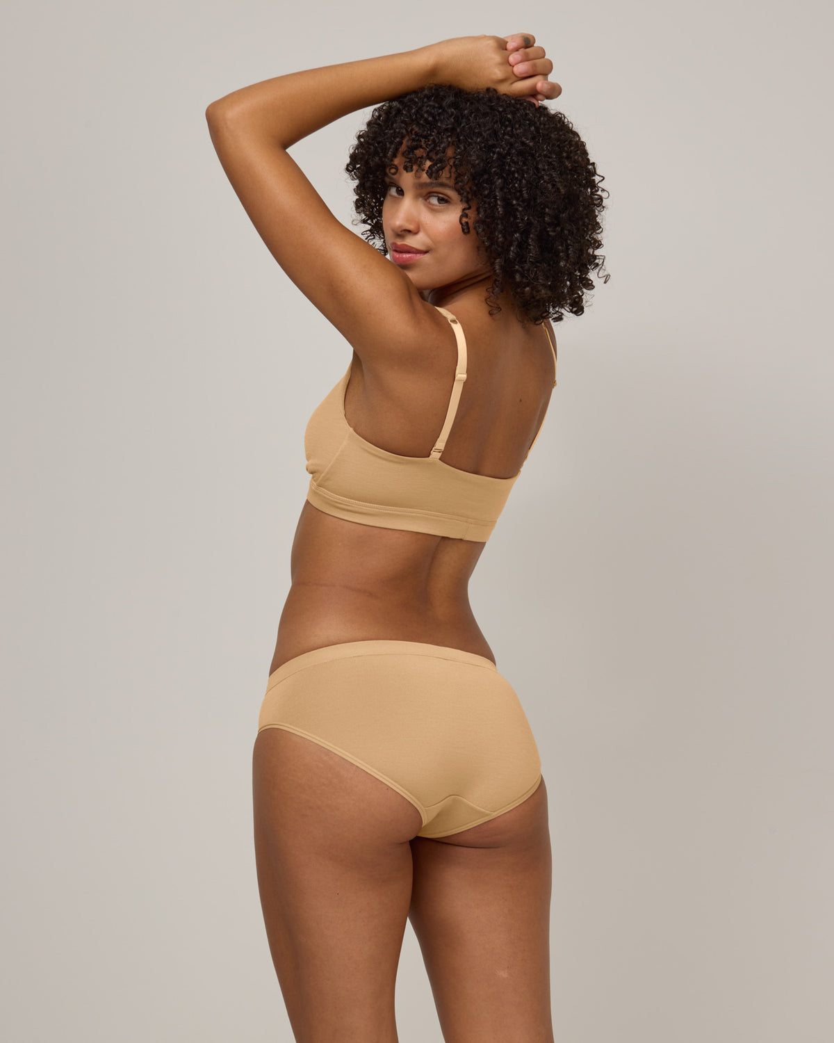 Model wearing Roam Bikini in Fawn, a light nude color. Roam Bikini is a merino wool underwear available in sizes XS-3X.