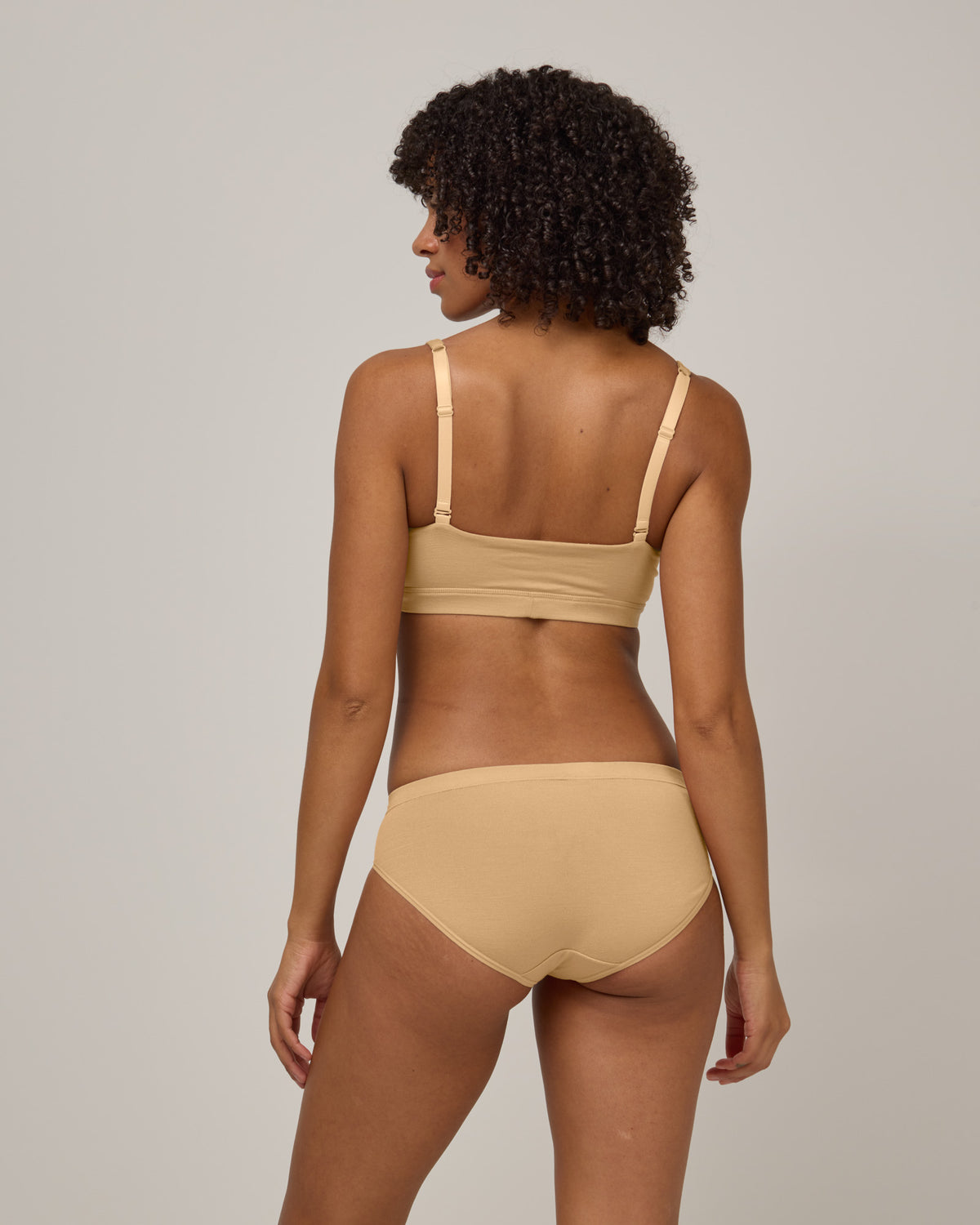 Model wearing Roam Convertible Wrap Bra in Fawn, a light nude color. Roam Convertible Wrap Bra is a merino wool underwear available in sizes XS-XXL.