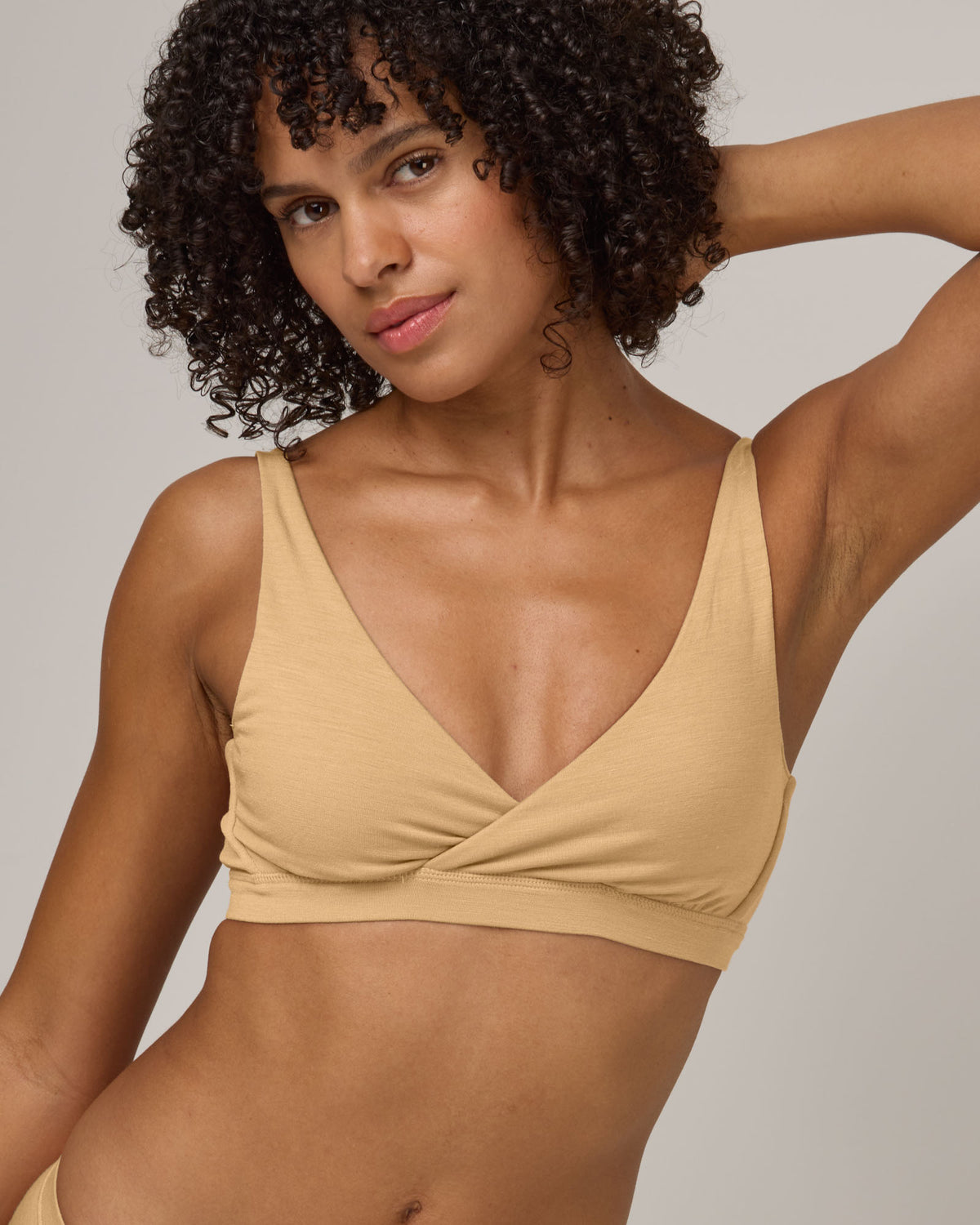 Model wearing Roam Convertible Wrap Bra in Fawn, a light nude color. Roam Convertible Wrap Bra is a merino wool underwear available in sizes XS-XXL.
