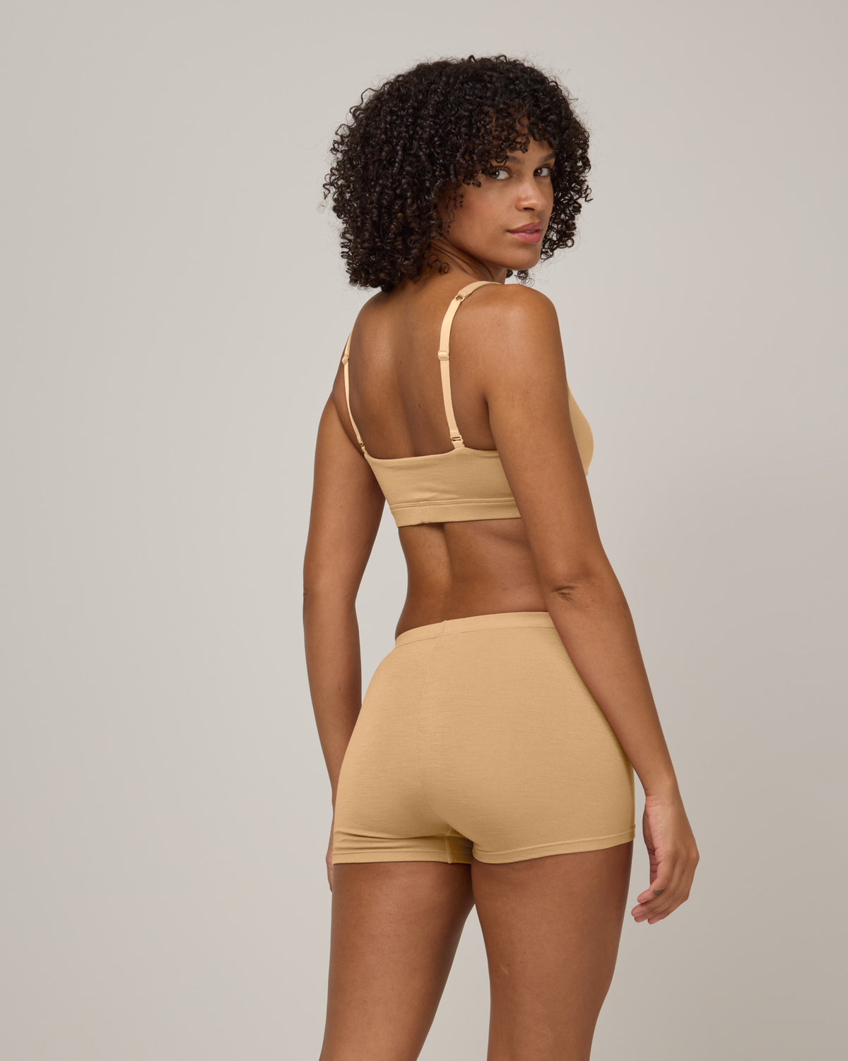 Model wearing Roam High Waist Shortie in Fawn, a light nude color. Roam High Waist Shortie is a merino wool underwear available in sizes XS-3X.