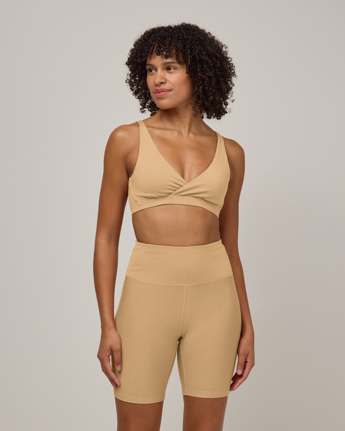 Model wearing Roam Bike Short in Fawn, a light nude color. Roam Bike Short is a merino wool short with pockets available in sizes XS-3X.