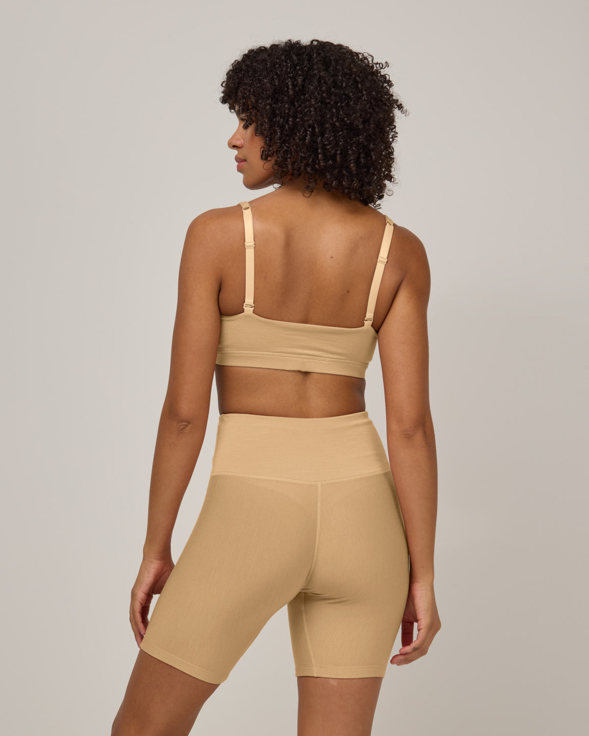 Model wearing Roam Bike Short in Fawn, a light nude color. Roam Bike Short is a merino wool short with pockets available in sizes XS-3X.