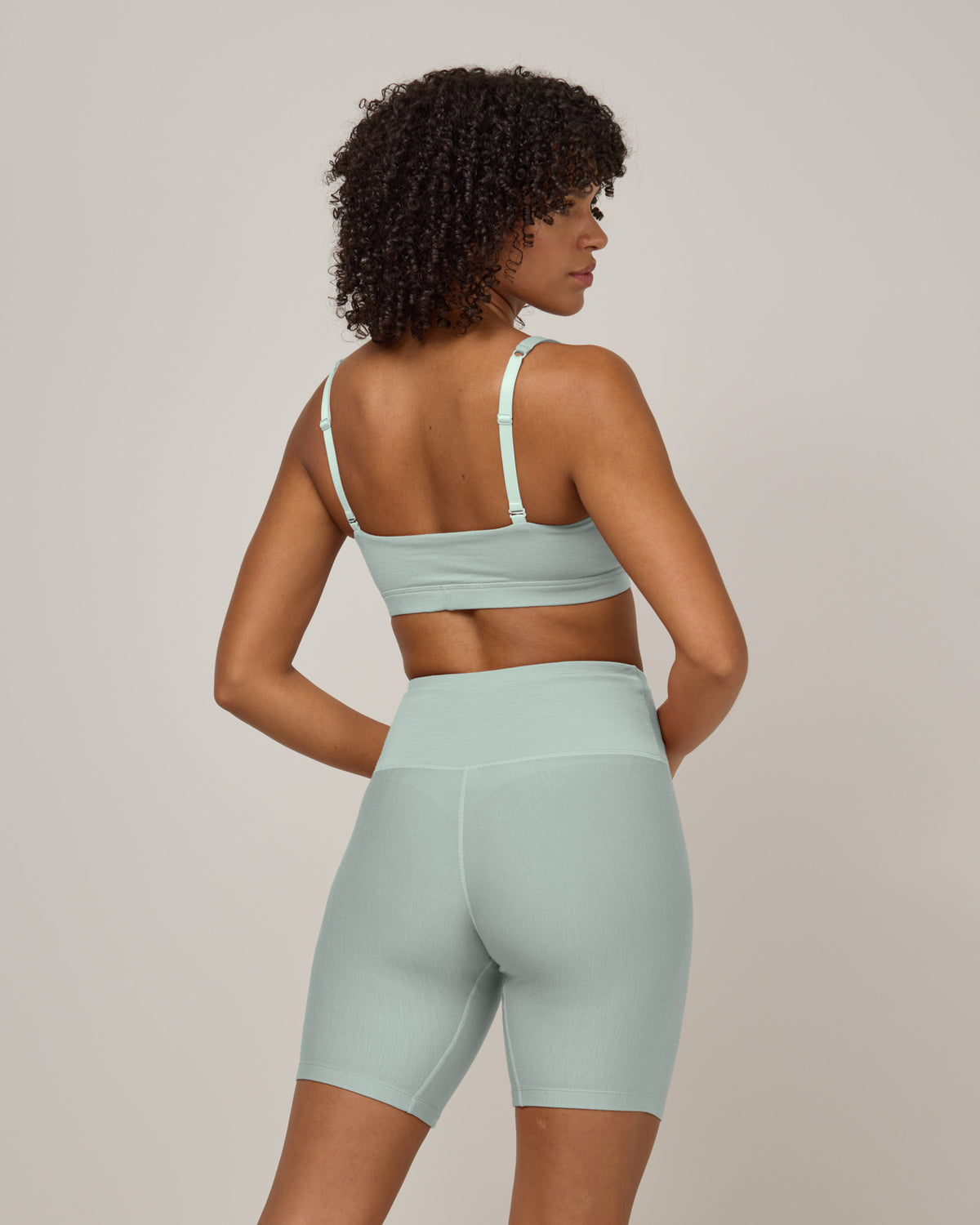 Model wearing Roam Bike Short in Morning Dew, a vivid mint green color. Roam Bike Short is a merino wool short with pockets available in sizes XS-3X.