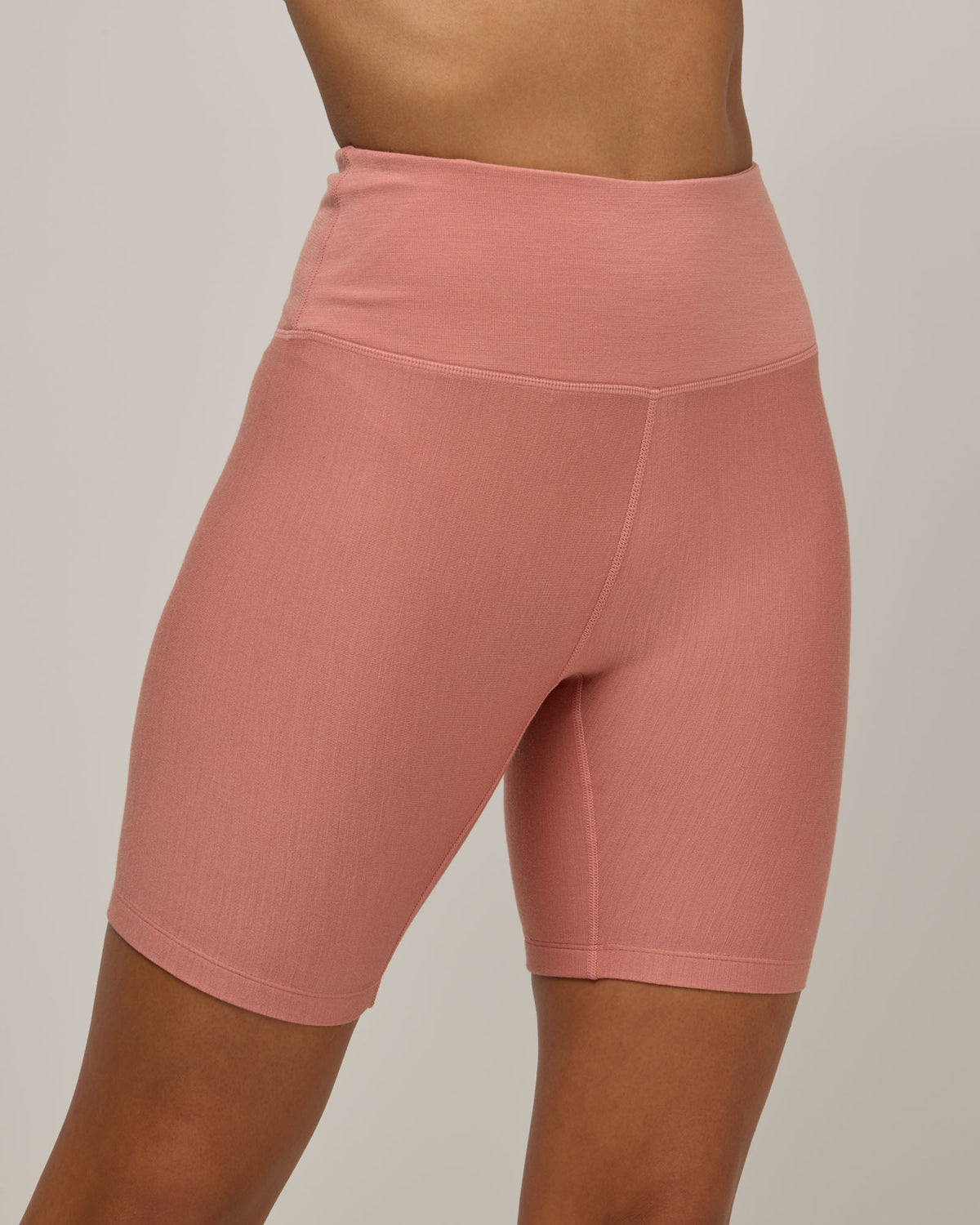 Model wearing Roam Bike Short in Vintage Rose, a soft muted pink color. Roam Bike Short is a merino wool short with pockets available in sizes XS-3X.