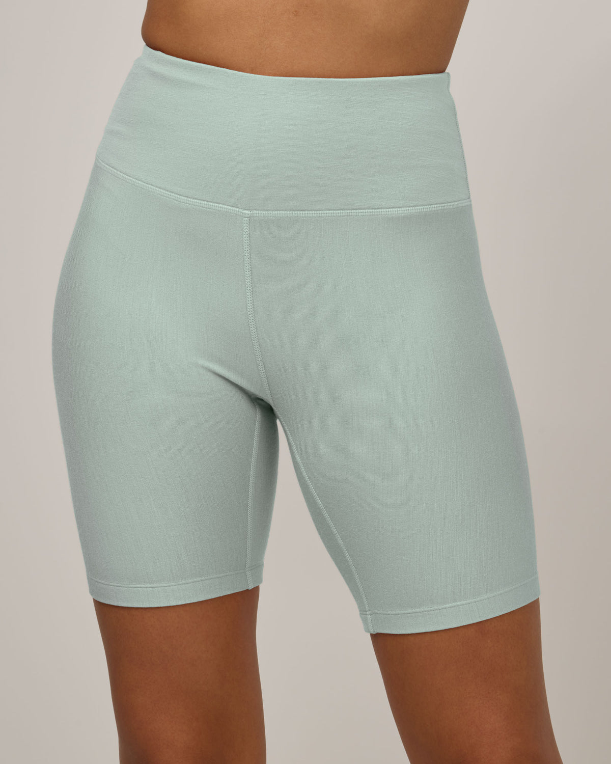 Model wearing Roam Bike Short in Morning Dew, a vivid mint green color. Roam Bike Short is a merino wool short with pockets available in sizes XS-3X.