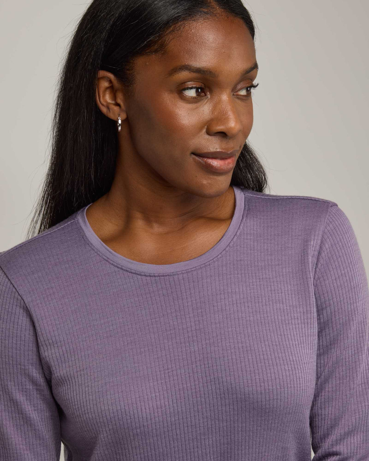 Model wearing Bethany Double Knit Ribbed Dress in Purple Sage, a soft, muted purple color. Bethany Double Knit Ribbed Dress is a merino wool long sleeve, crew neck, midi swing dress with pockets available in sizes XS-3X.