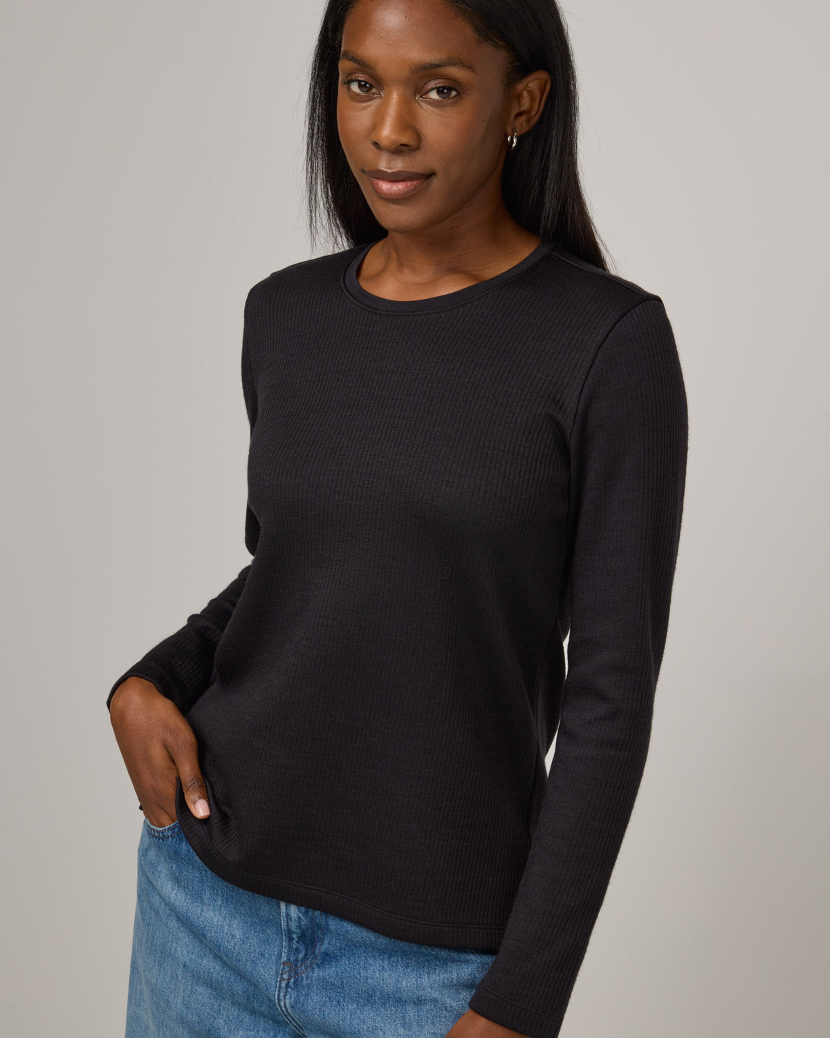 Model wearing Rayne Double Knit Ribbed Top in Black. Rayne Double Knit Ribbed Top is a merino wool long sleeve, crew neck, slim fit top available in sizes XS-3X.