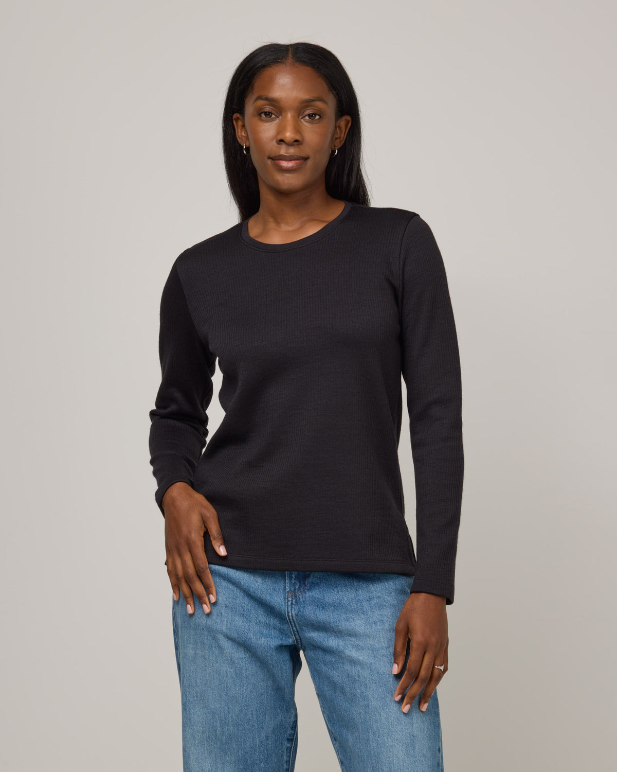 Model wearing Rayne Double Knit Ribbed Top in Black. Rayne Double Knit Ribbed Top is a merino wool long sleeve, crew neck, slim fit top available in sizes XS-3X.