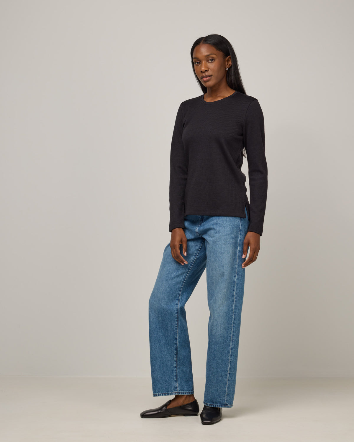 Model wearing Rayne Double Knit Ribbed Top in Black. Rayne Double Knit Ribbed Top is a merino wool long sleeve, crew neck, slim fit top available in sizes XS-3X.