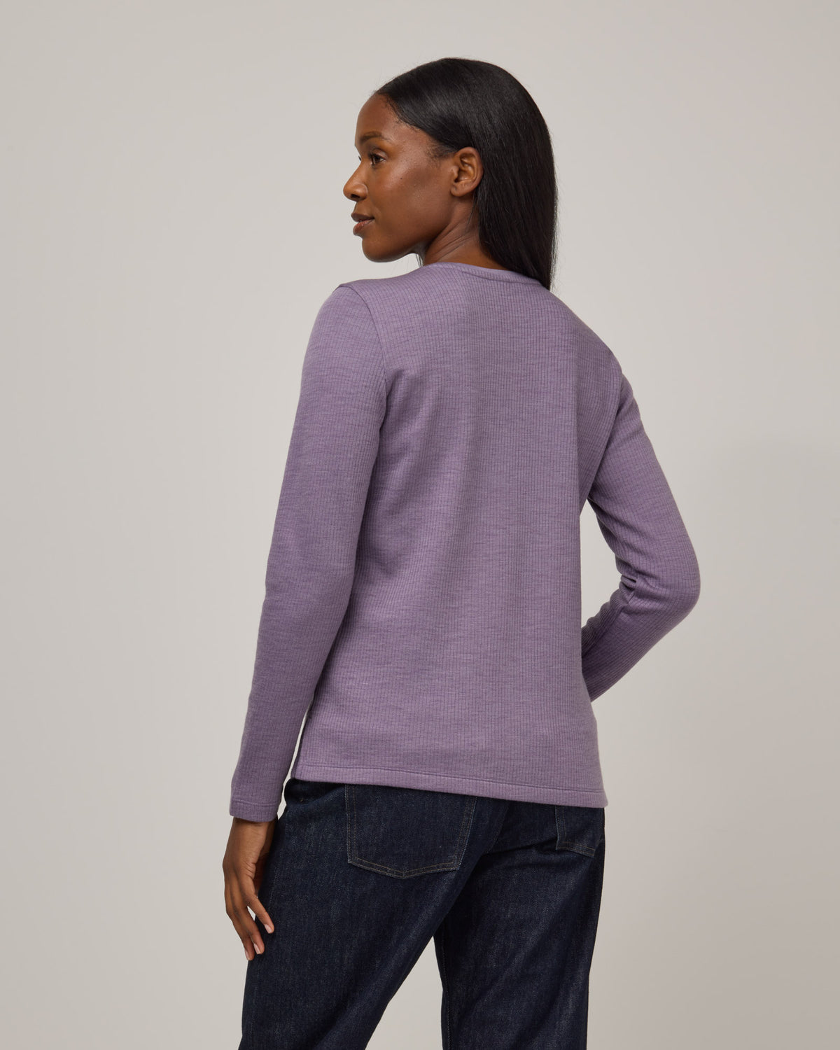 Model wearing Rayne Double Knit Ribbed Top in Purple Sage, a soft, muted purple color. Rayne Double Knit Ribbed Top is a merino wool long sleeve, crew neck, slim fit top available in sizes XS-3X.