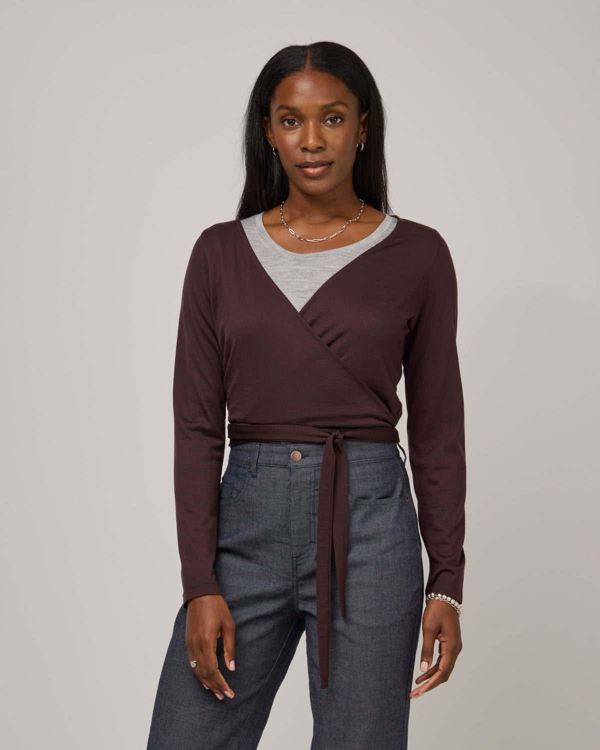 Model wearing Natalia Wrap Top in Espresso, a dark brown color. Natalia Wrap Top is a merino wool long sleeve, v-neck, slim fit top available in sizes XS-3X.