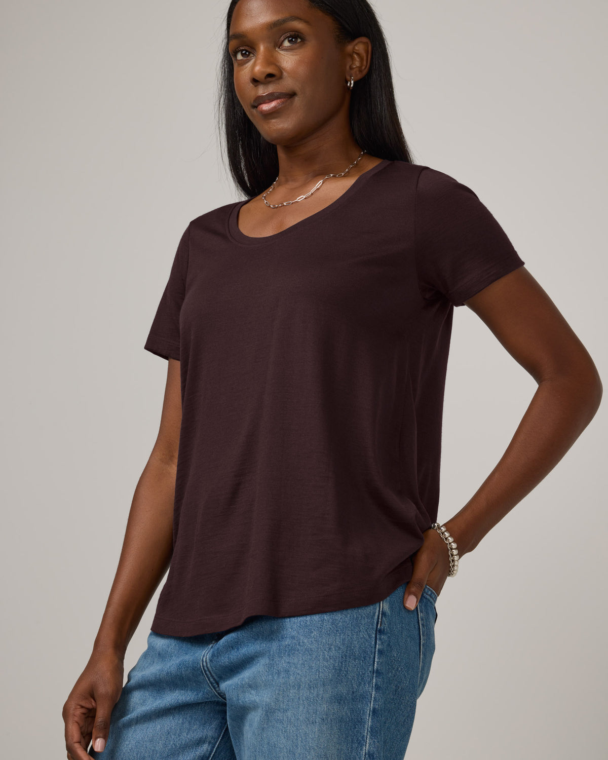 Model wearing Stella Signature Scoop Neck Tee in Espresso, a dark brown color. Stella Signature Scoop Neck Tee is a merino wool short sleeve, scoop neck, relaxed fit tee available in sizes XS-3X.