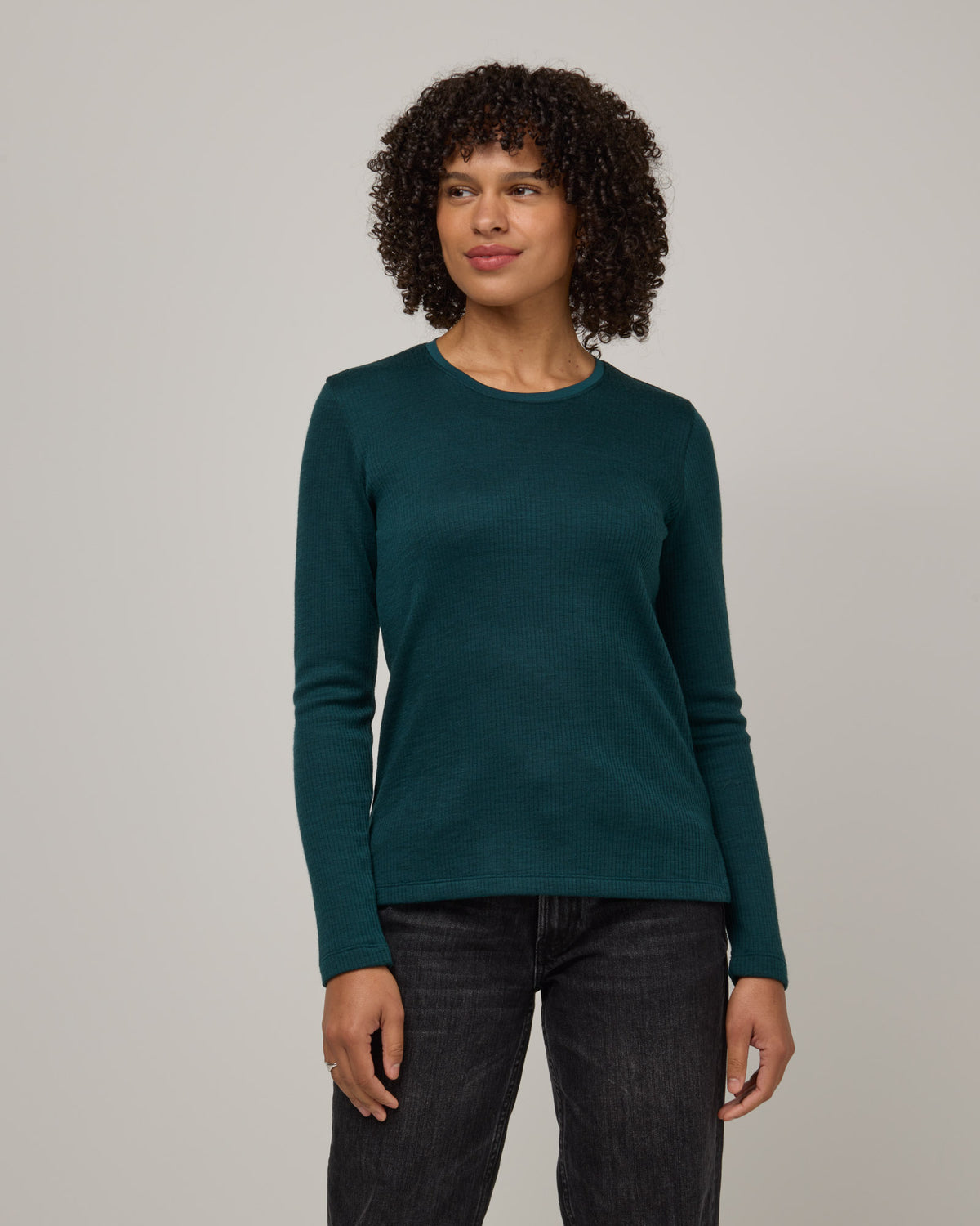 Model wearing Rayne Double Knit Ribbed Top in Pine, a saturated forest green color. Rayne Double Knit Ribbed Top is a merino wool long sleeve, crew neck, slim fit top available in sizes XS-3X.