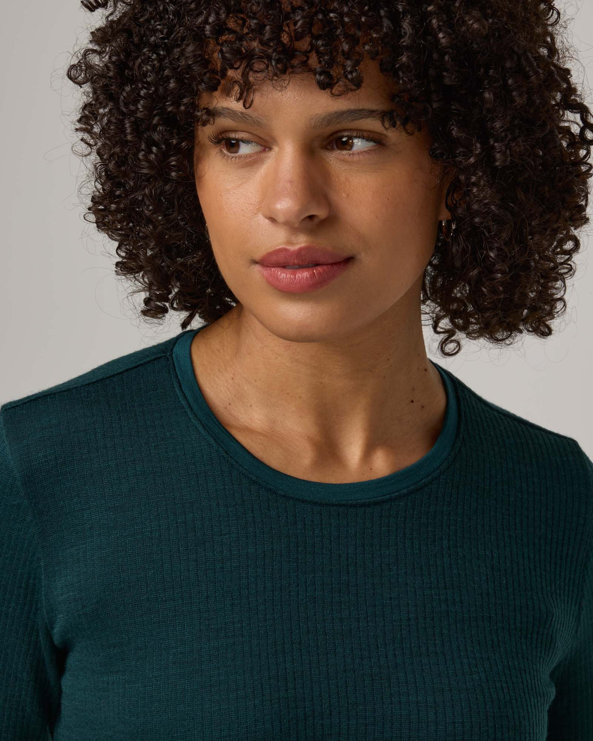 Model wearing Rayne Double Knit Ribbed Top in Pine, a saturated forest green color. Rayne Double Knit Ribbed Top is a merino wool long sleeve, crew neck, slim fit top available in sizes XS-3X.