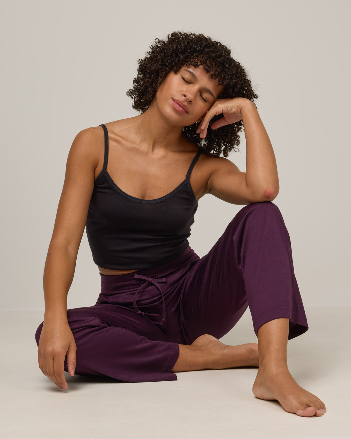Model wearing Twilight Sleep Pant in Marionberry, a dark berry purple color. Twilight Sleep Pant is a merino wool pant with pockets available in sizes XS-XXL.