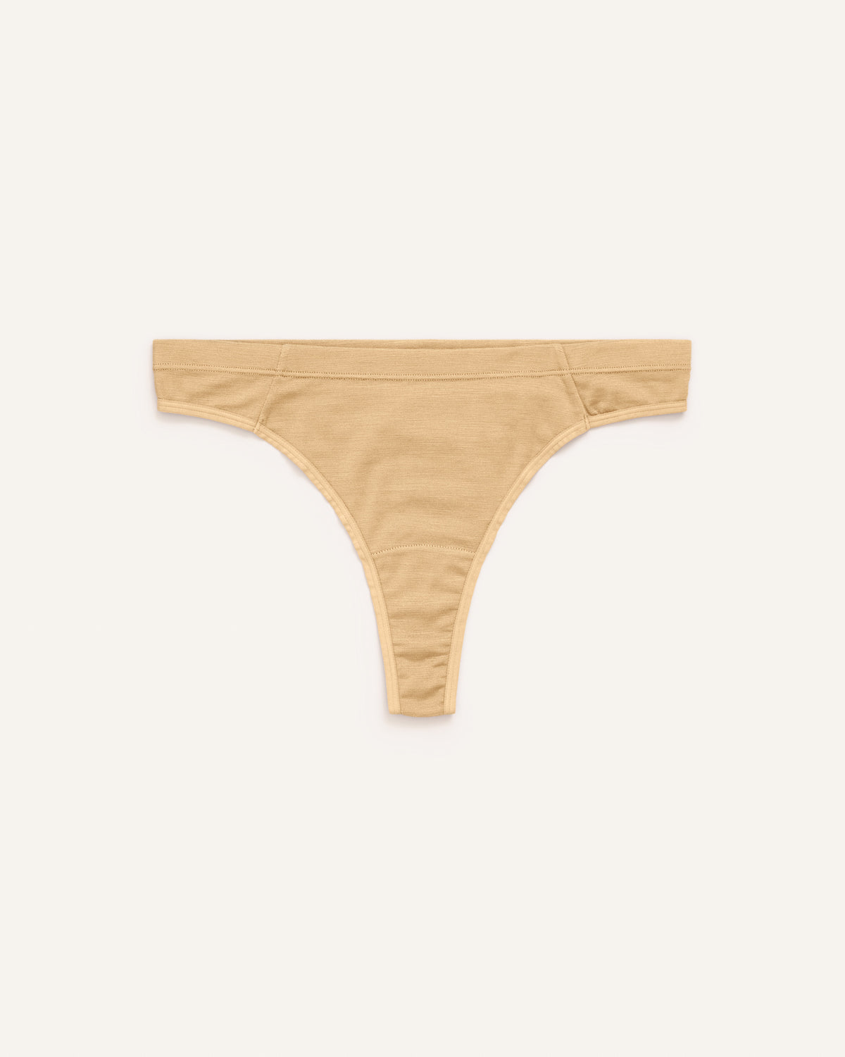 Laydown of Roam Thong in Fawn, a light nude color. Roam Thong is a merino wool underwear available in sizes XS-3X.