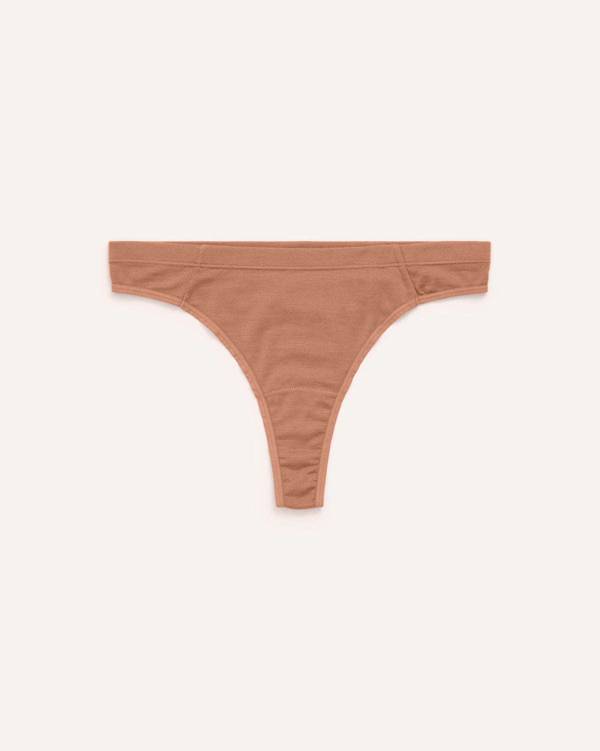 Laydown of Roam Thong in Mocha Brown, a medium-dark nude color. Roam Thong is a merino wool underwear available in sizes XS-3X