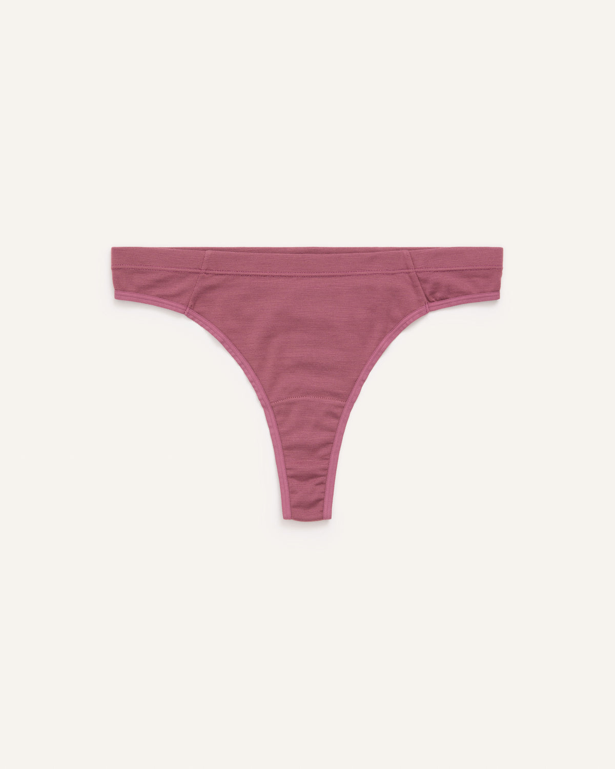 Laydown of Roam Thong in Rosewood, a muted, dark pink-purple color . Roam Thong is a merino wool underwear available in sizes XS-3X.