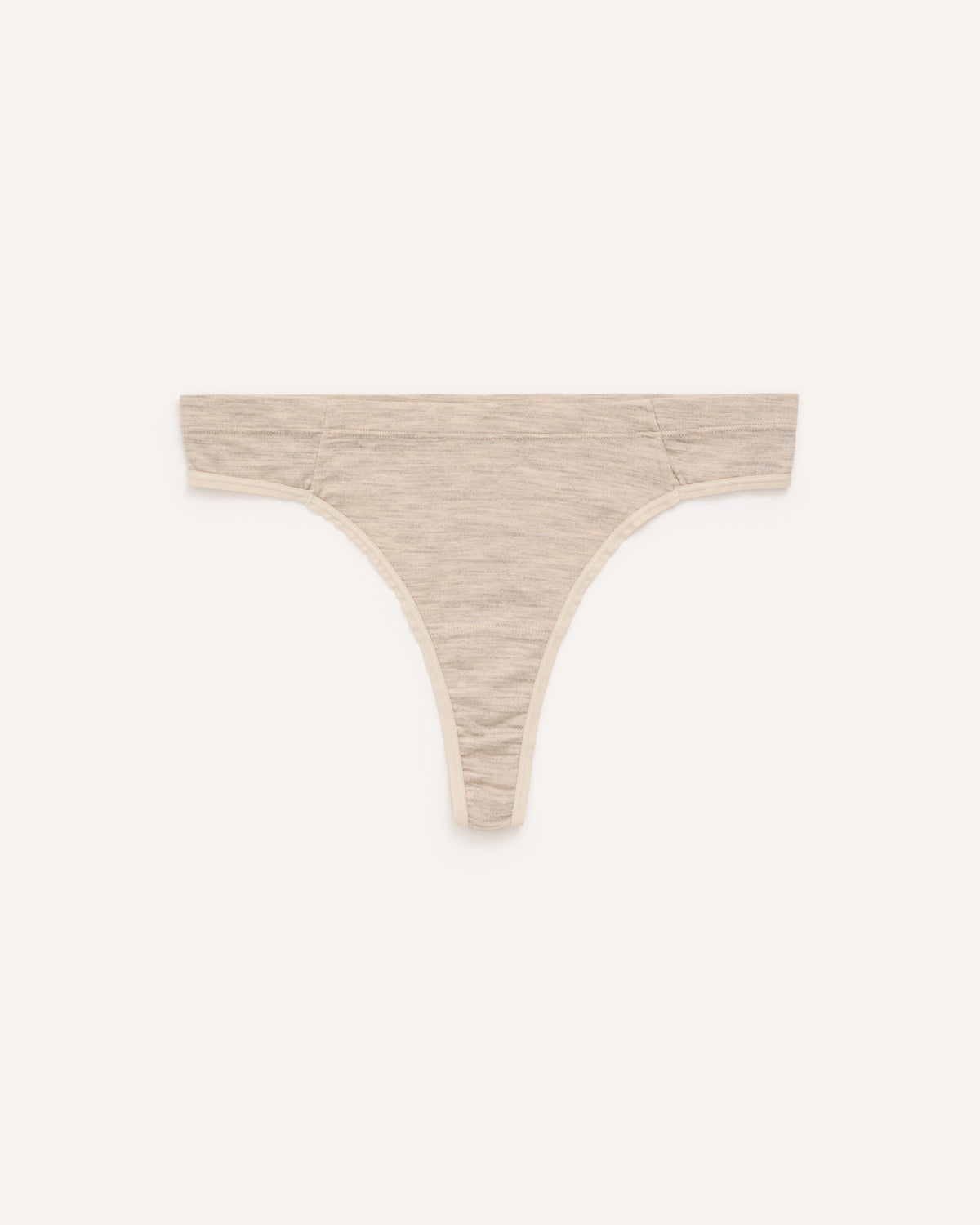 Laydown of Roam Thong in Oatmeal Heather, a soft heathered cream color. Roam Thong is a merino wool underwear available in sizes XS-3X.