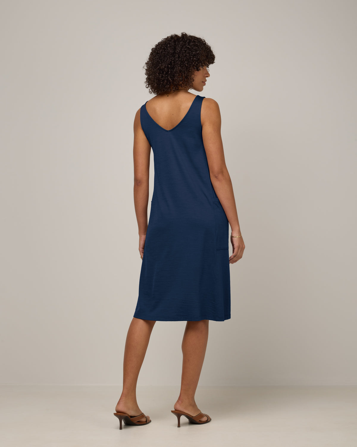 Model wearing Summer Reversible Dress in Marine Blue, a deep royal blue color. Summer Reversible Dress is a merino wool sleeveless, reversible, midi swing dress with pockets available in sizes XS-3X.