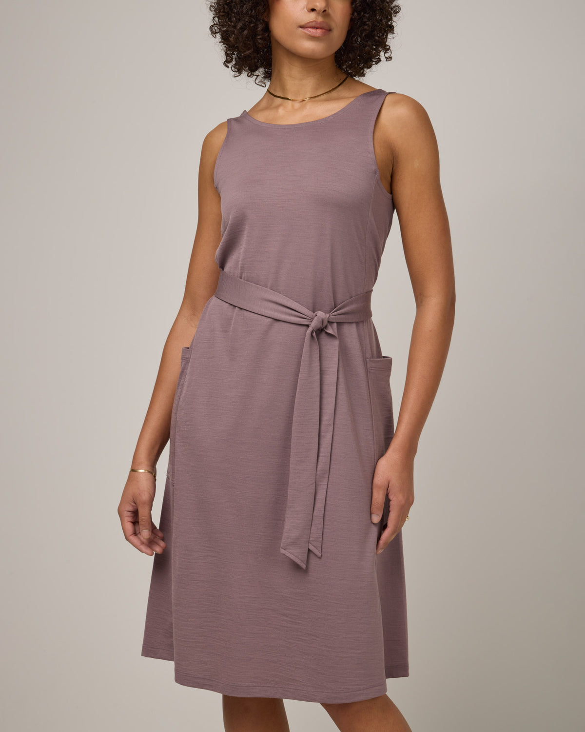 Model wearing Summer Reversible Dress in Lavender, a dusky, muted purple color. Summer Reversible Dress is a merino wool sleeveless, reversible, midi swing dress with pockets available in sizes XS-3X.