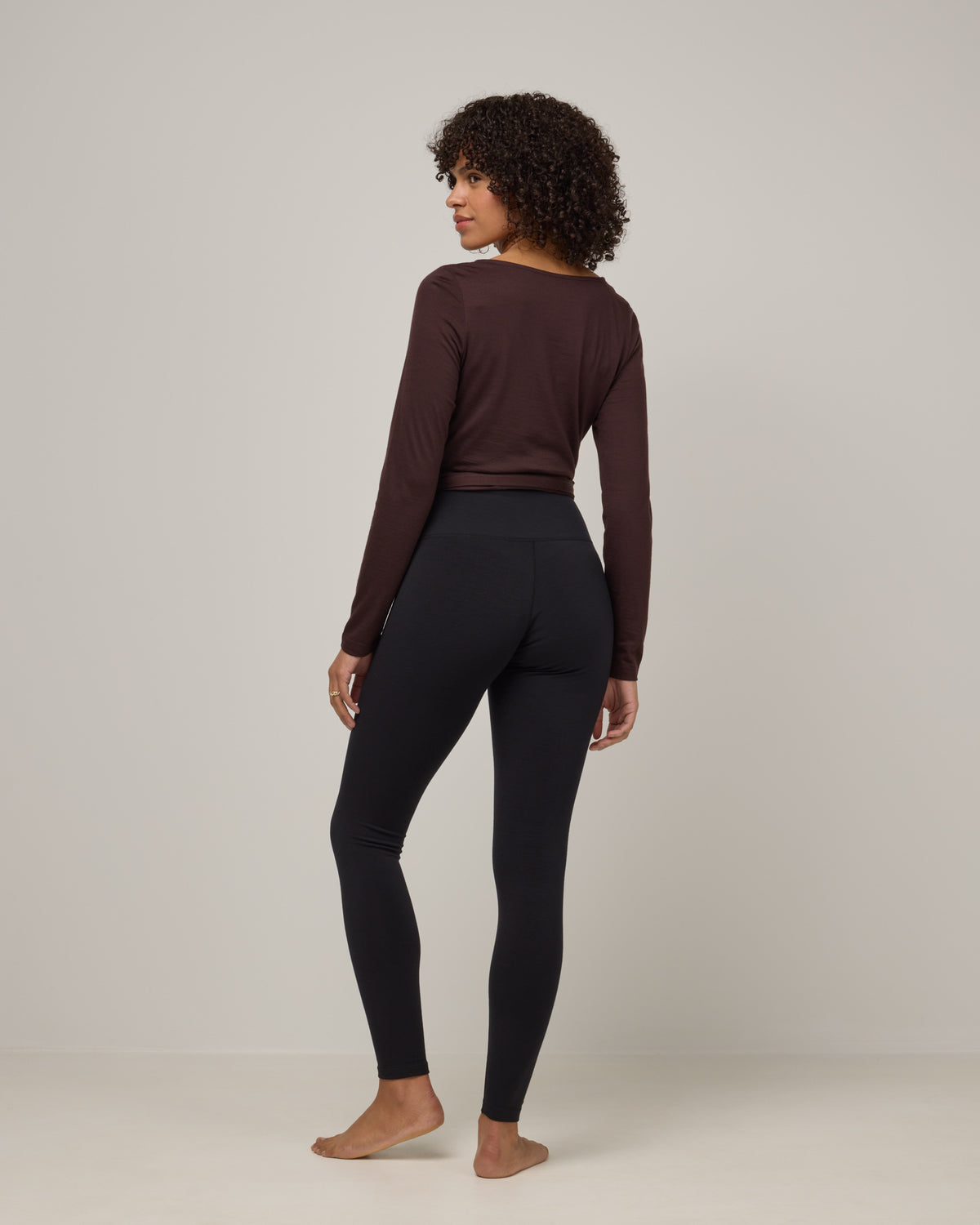 Model wearing Summit Legging in Black. Summit Legging is a merino wool legging available in sizes XS-3X Regular, S-XXL Long.