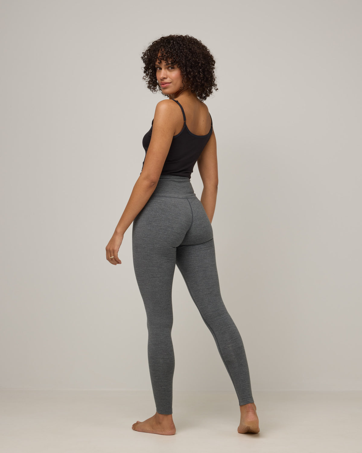 Model wearing Summit Legging in Charcoal Heather. Summit Legging is a merino wool legging available in sizes XS-3X Regular, S-XXL Long.