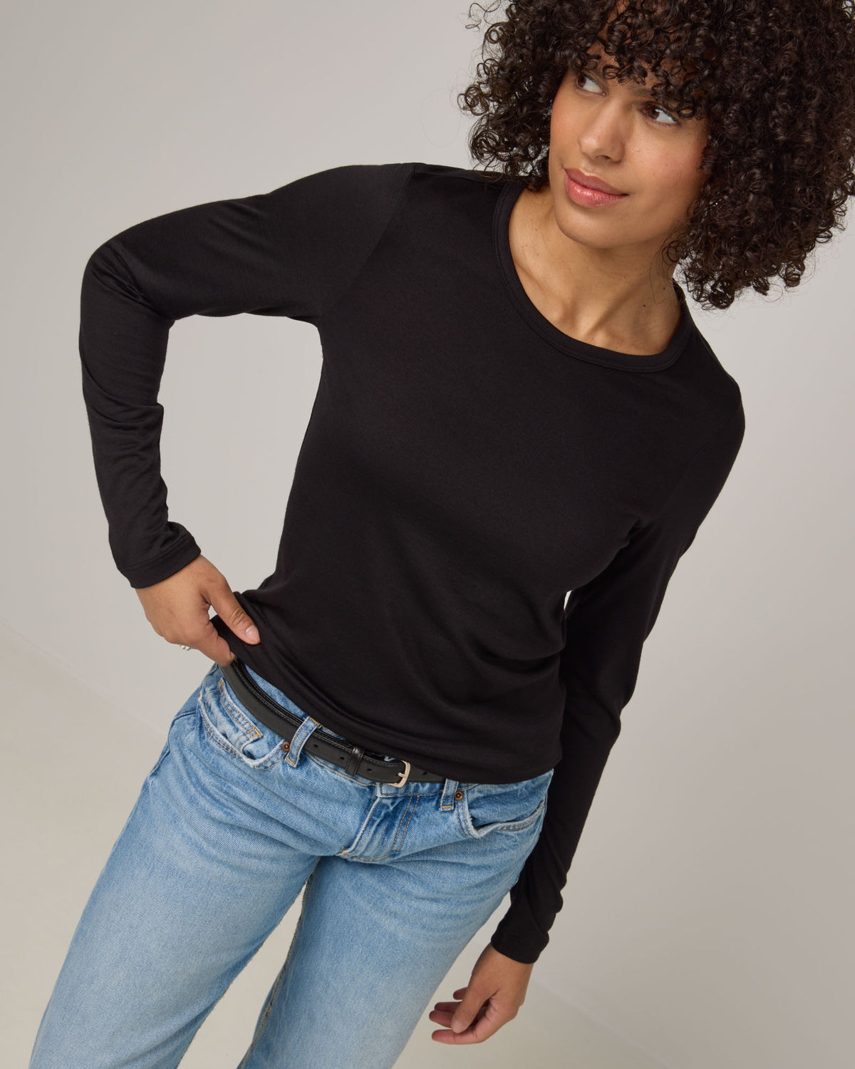 Model wearing Sloan 100% Wool Fitted Tee in Black. Sloan 100% Wool Fitted Tee is a merino wool long sleeve, crew neck, slim fit tee available in sizes XS-3X.