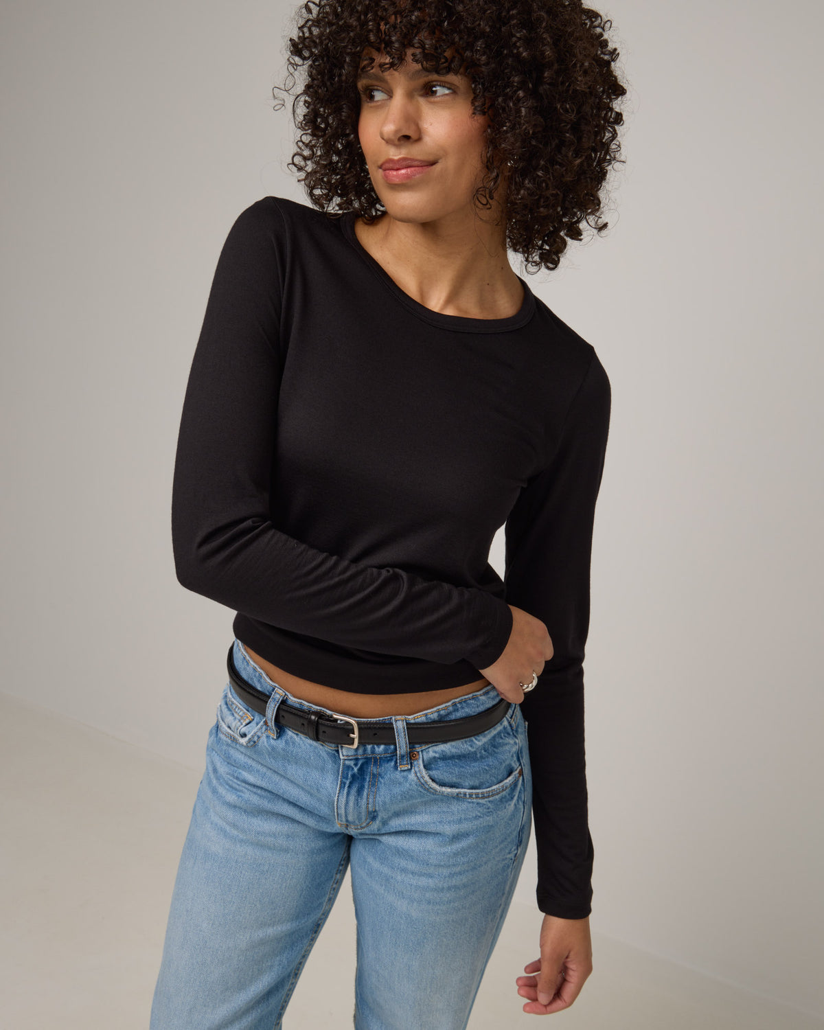 Model wearing Sloan Signature Fitted Tee in Black. Sloan Signature Fitted Tee is a merino wool long sleeve, crew neck, slim fit tee available in sizes XS-3X.