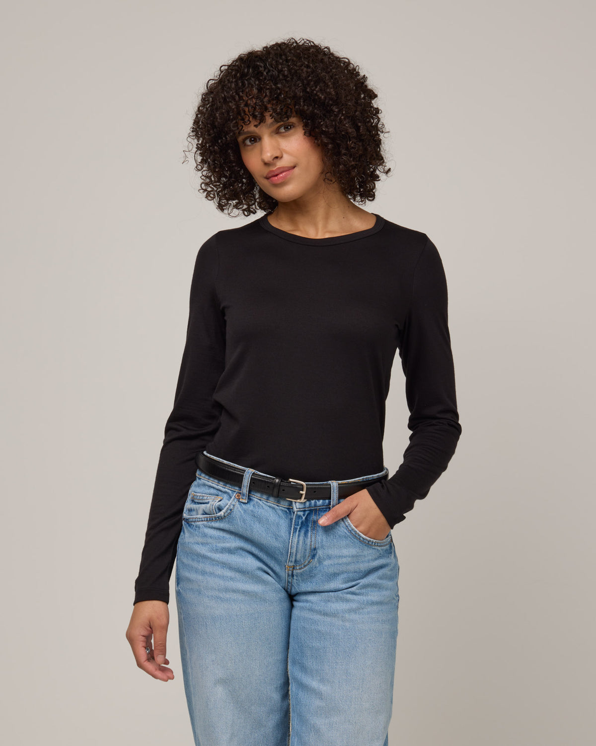 Model wearing Sloan 100% Wool Fitted Tee in Black. Sloan 100% Wool Fitted Tee is a merino wool long sleeve, crew neck, slim fit tee available in sizes XS-3X.