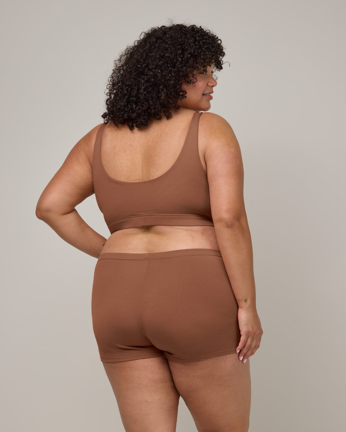 Model wearing Roam High Waist Shortie in Mocha Brown, a medium-dark nude color. Roam High Waist Shortie is a merino wool underwear available in sizes XS-3X.
