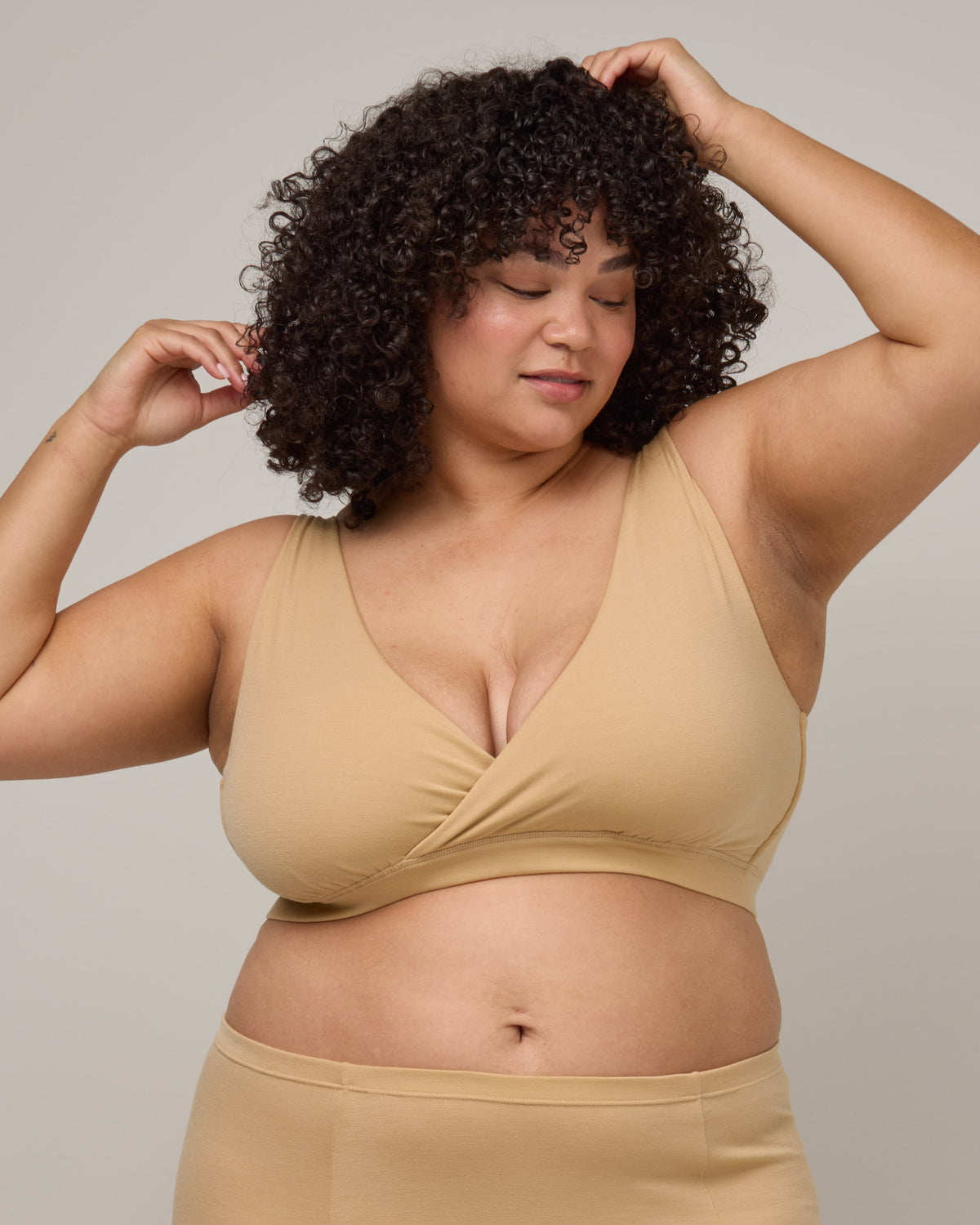 Model wearing Roam Wrap Bra in Fawn, a light nude color. Roam Wrap Bra is a merino wool underwear available in sizes 1X-3X.