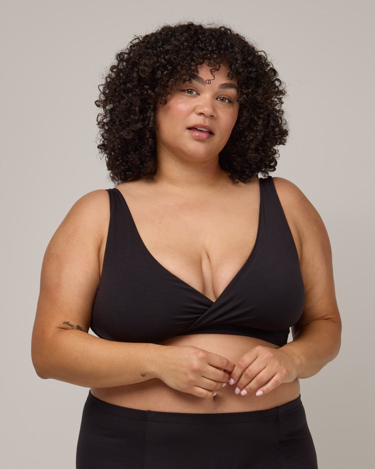 Model wearing Roam Wrap Bra in Black. Roam Wrap Bra is a merino wool underwear available in sizes 1X-3X.