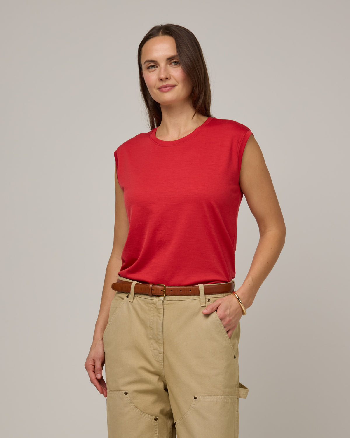 Model wearing Dawn Boxy Tank in Fruit Punch, a vivid red-orange color. Dawn Boxy Tank is a merino wool sleeveless, crew neck, relaxed fit top available in sizes XS-3X.
