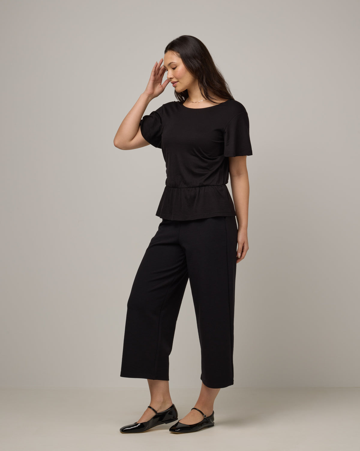 Model wearing Jeanne Flutter Sleeve Top in . Jeanne Flutter Sleeve Top is a merino wool short sleeve, reversible, regular fit top available in sizes XS-XXL.