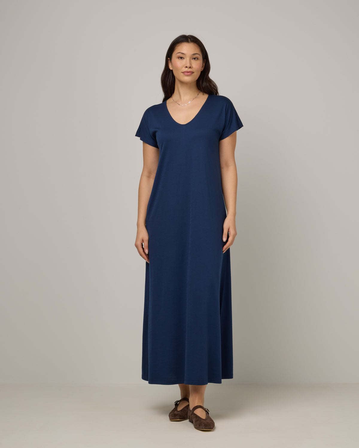 Model wearing Freya Maxi Dress in Marine Blue, a deep royal blue color. Freya Maxi Dress is a merino wool short sleeve, v-neck, maxi swing dress with pockets available in sizes XS-3X.