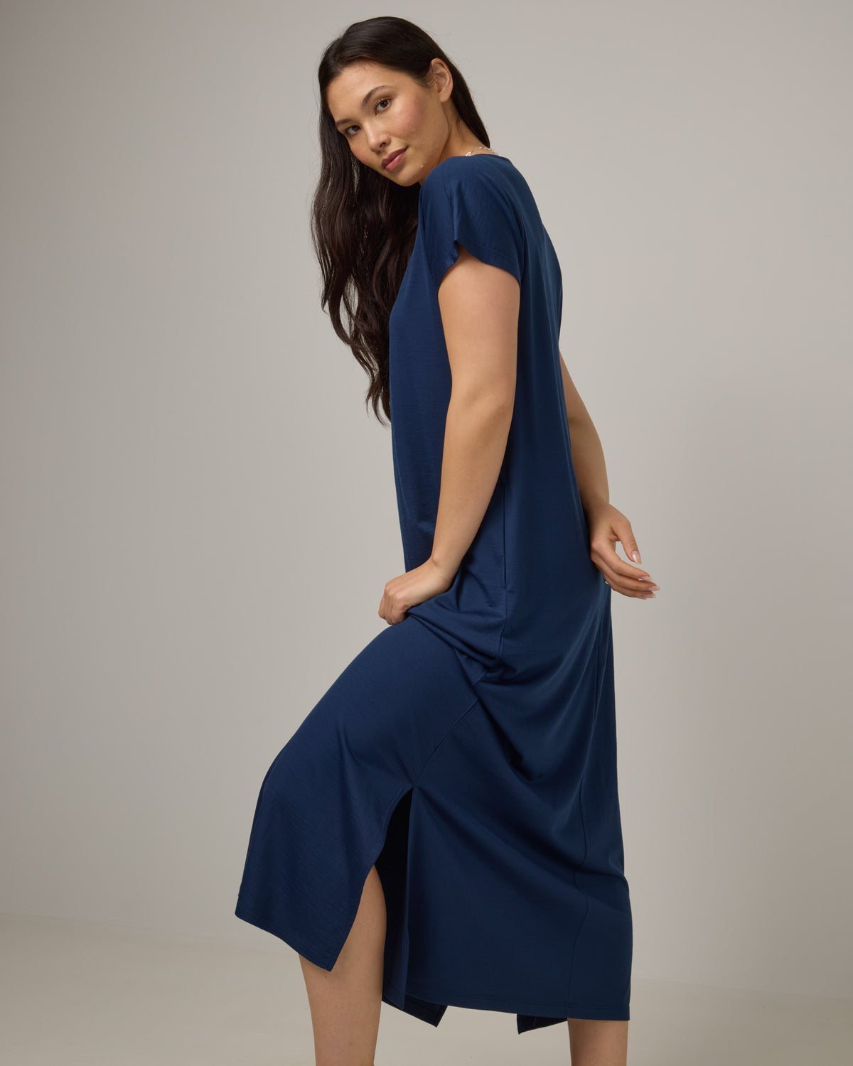 Model wearing Freya Maxi Dress in Marine Blue, a deep royal blue color. Freya Maxi Dress is a merino wool short sleeve, v-neck, maxi swing dress with pockets available in sizes XS-3X.