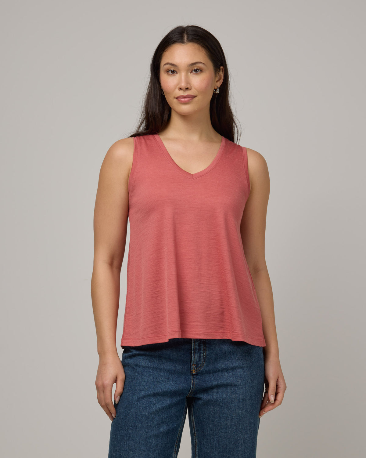 Model wearing Poppy Signature Reversible Tank in Dusty Cedar, a soft pink-coral color. Poppy Signature Reversible Tank is a merino wool sleeveless, reversible, relaxed fit top available in sizes XS-3X.