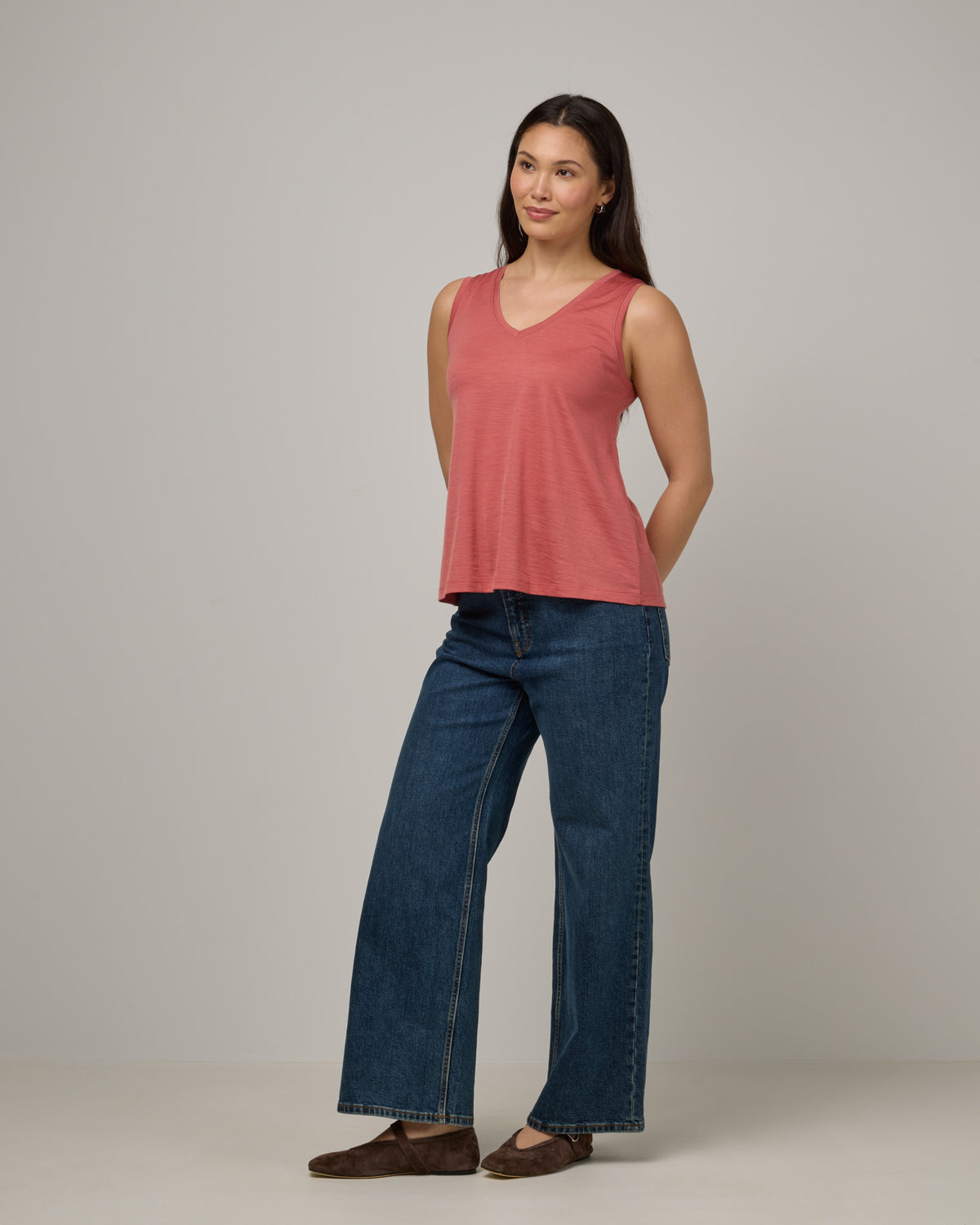 Model wearing Poppy Signature Reversible Tank in Dusty Cedar, a soft pink-coral color. Poppy Signature Reversible Tank is a merino wool sleeveless, reversible, relaxed fit top available in sizes XS-3X.