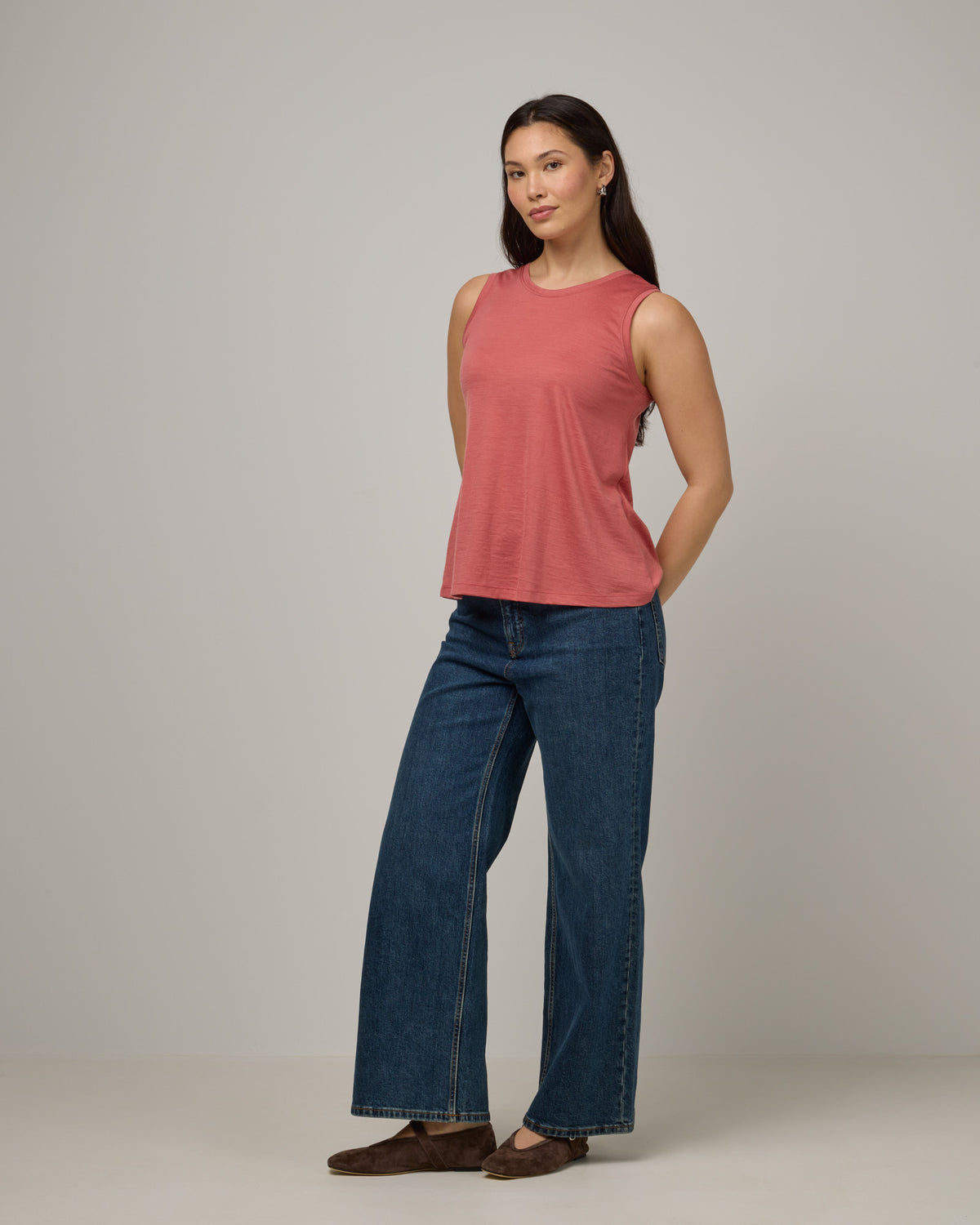 Model wearing Poppy Signature Reversible Tank in Dusty Cedar, a soft pink-coral color. Poppy Signature Reversible Tank is a merino wool sleeveless, reversible, relaxed fit top available in sizes XS-3X.