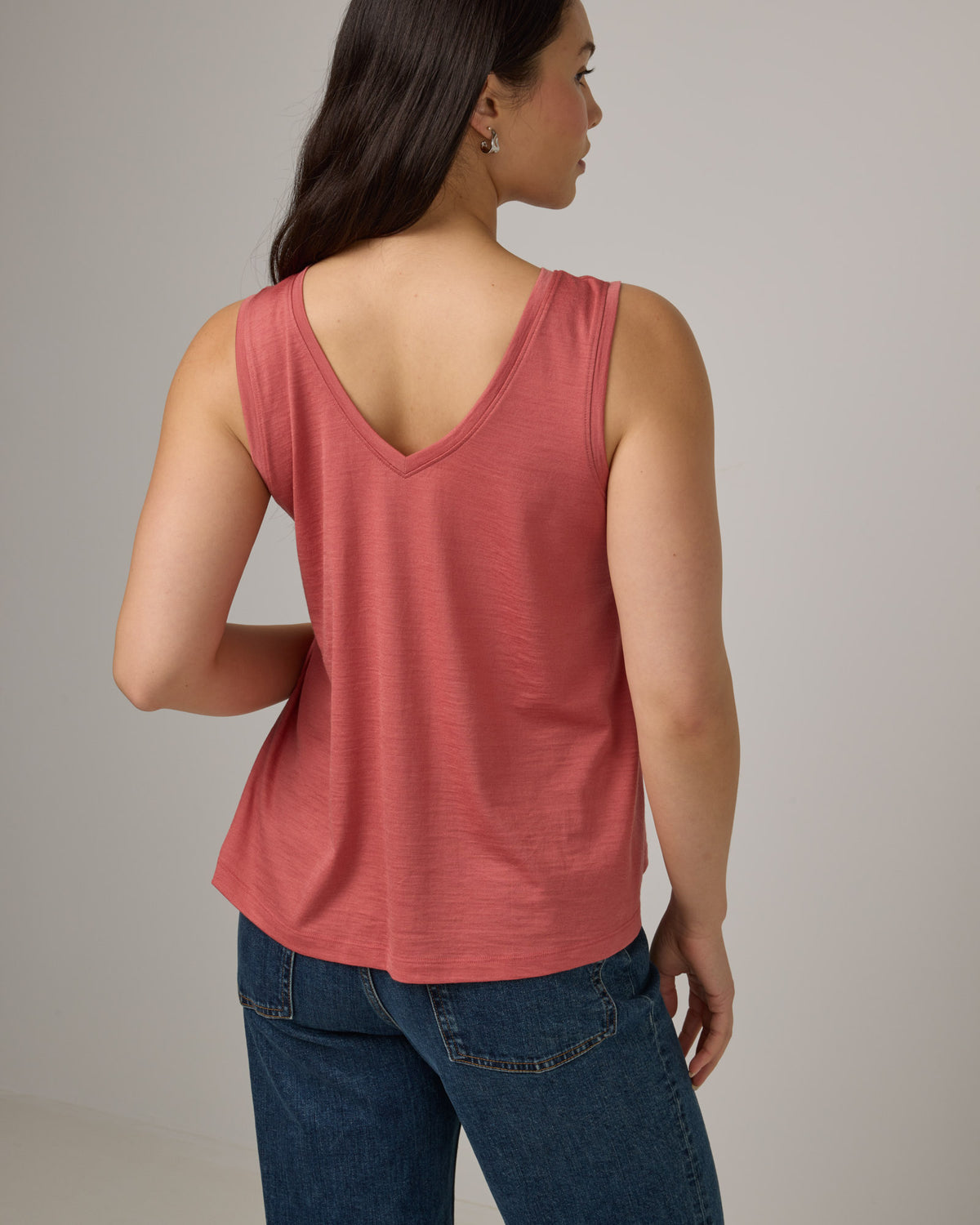 Model wearing Poppy Signature Reversible Tank in Dusty Cedar, a soft pink-coral color. Poppy Signature Reversible Tank is a merino wool sleeveless, reversible, relaxed fit top available in sizes XS-3X.
