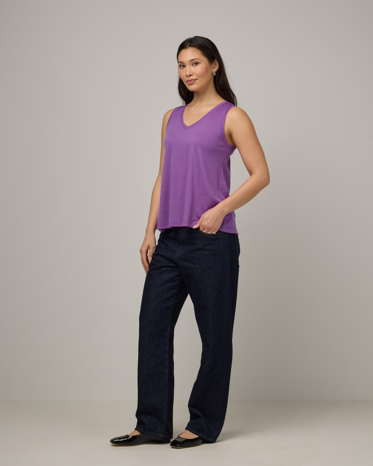 Model wearing Poppy Signature Reversible Tank in Purple Pansy, a bright, saturated purple color. Poppy Signature Reversible Tank is a merino wool sleeveless, reversible, relaxed fit top available in sizes XS-3X.