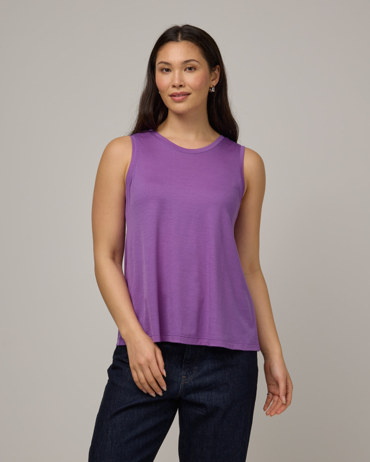 Model wearing Poppy Signature Reversible Tank in Purple Pansy, a bright, saturated purple color. Poppy Signature Reversible Tank is a merino wool sleeveless, reversible, relaxed fit top available in sizes XS-3X.