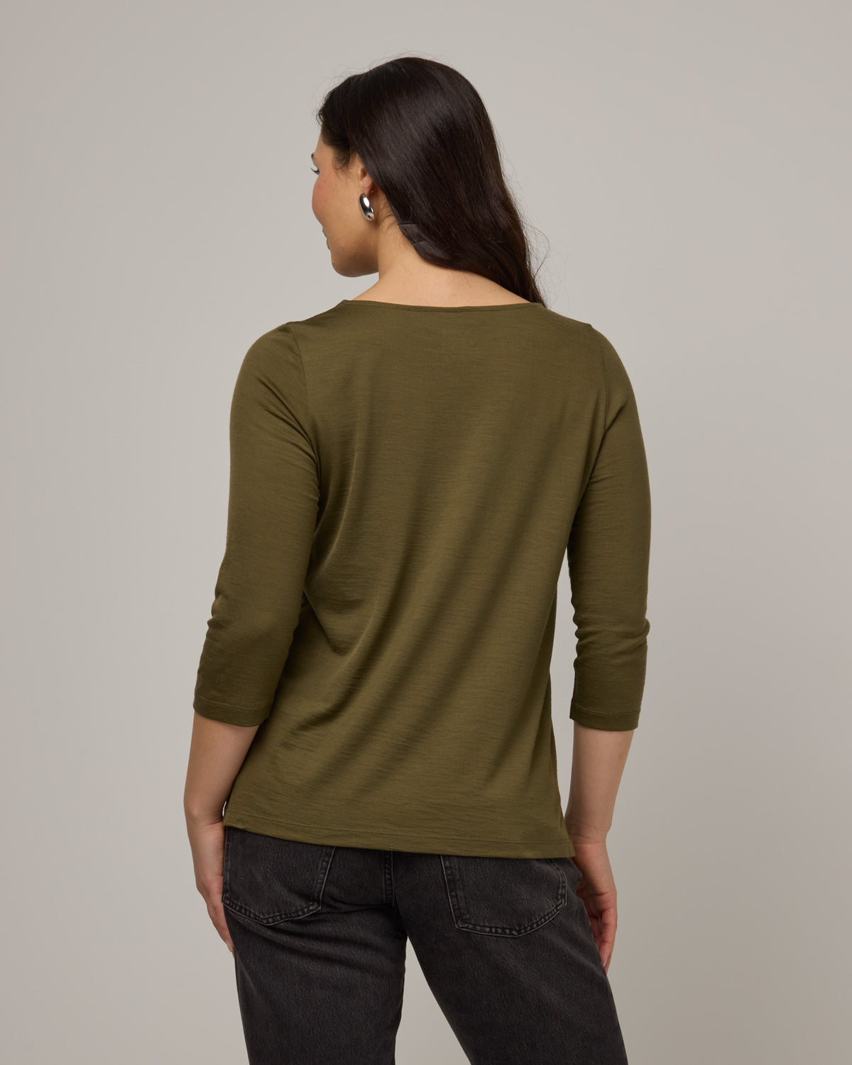 Model wearing Colette Quarter-Sleeve Top in Olive. Colette Quarter-Sleeve Top is a merino wool long sleeve, boatneck, regular fit top available in sizes XS-3X.
