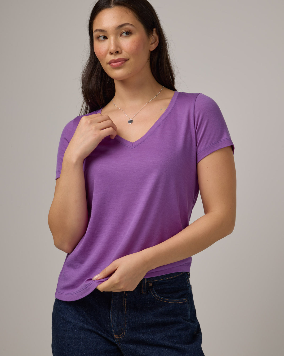 Model wearing Morgan V-Neck Tee in Purple Pansy, a bright, saturated purple color. Morgan V-Neck Tee is a merino wool short sleeve, v-neck, regular fit tee available in sizes XS-3X.