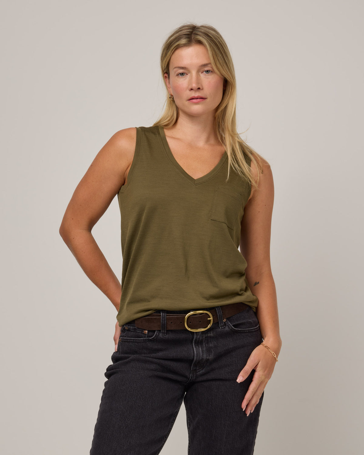 Model wearing Penelope Pocket Tank in Olive. Penelope Pocket Tank is a merino wool sleeveless, v-neck tank with a pocket available in sizes XS-3X.
